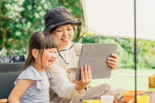 onpuのポータブルディスプレイを利用し、キャンプで動画を楽しむ子供と母親